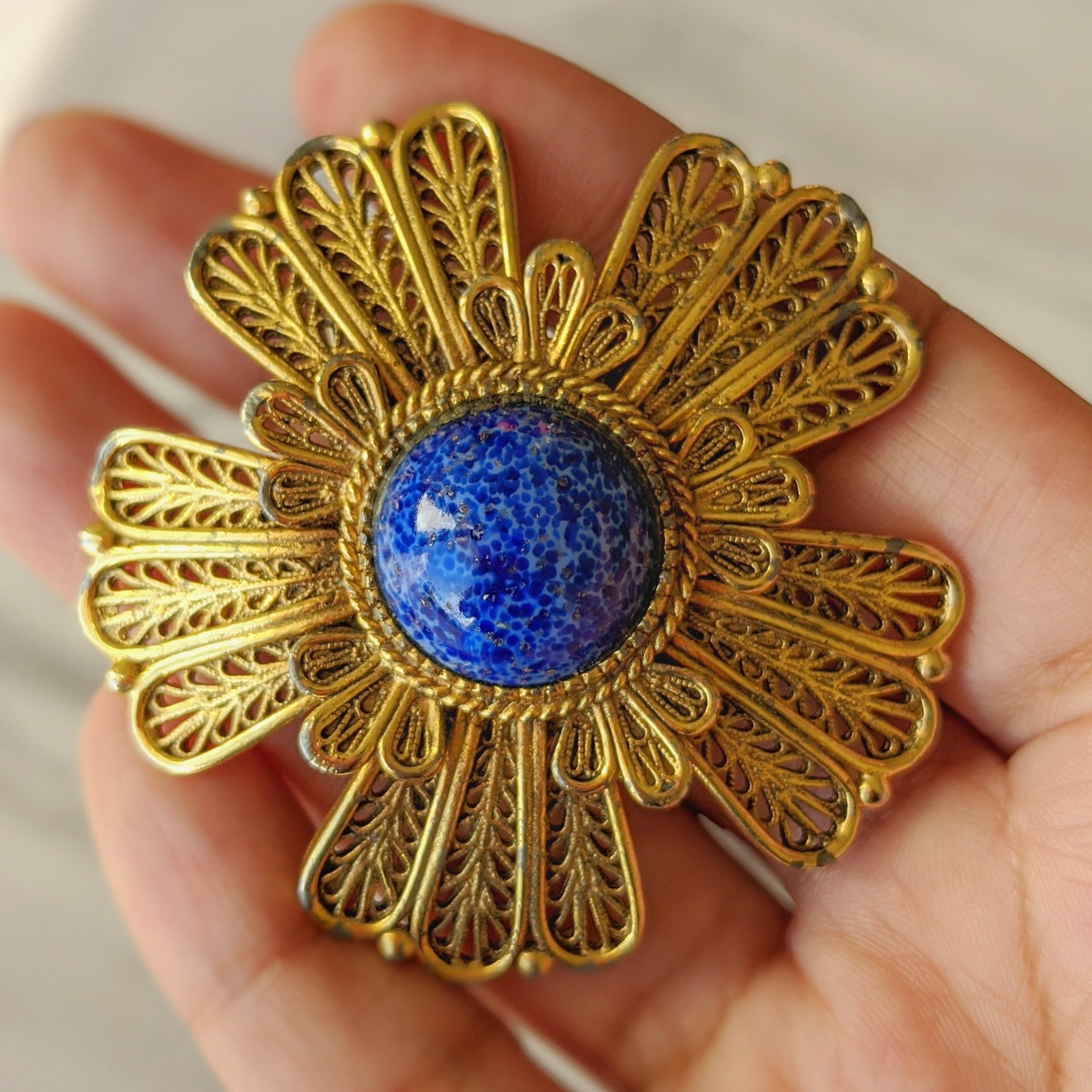 The 1960s costume Lapis Lazuli designer brooch in a woman's hand