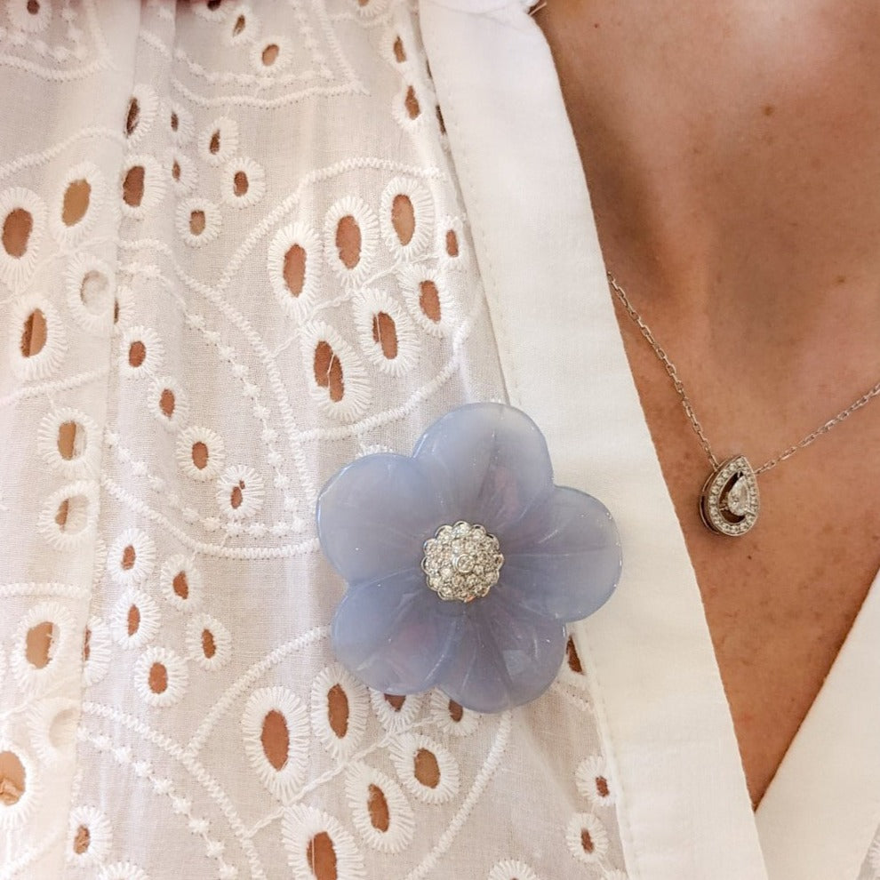 Statement blue chalcedony and diamond brooch worn on a woman’s white shirt.  