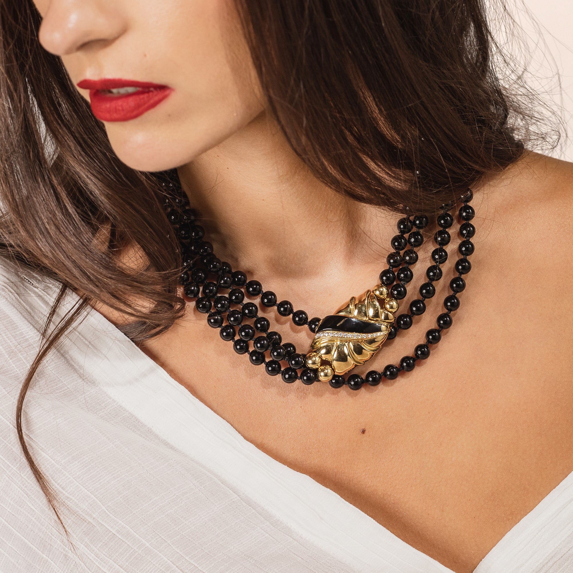 Italian black onyx beaded necklace worn short around woman’s neck. 