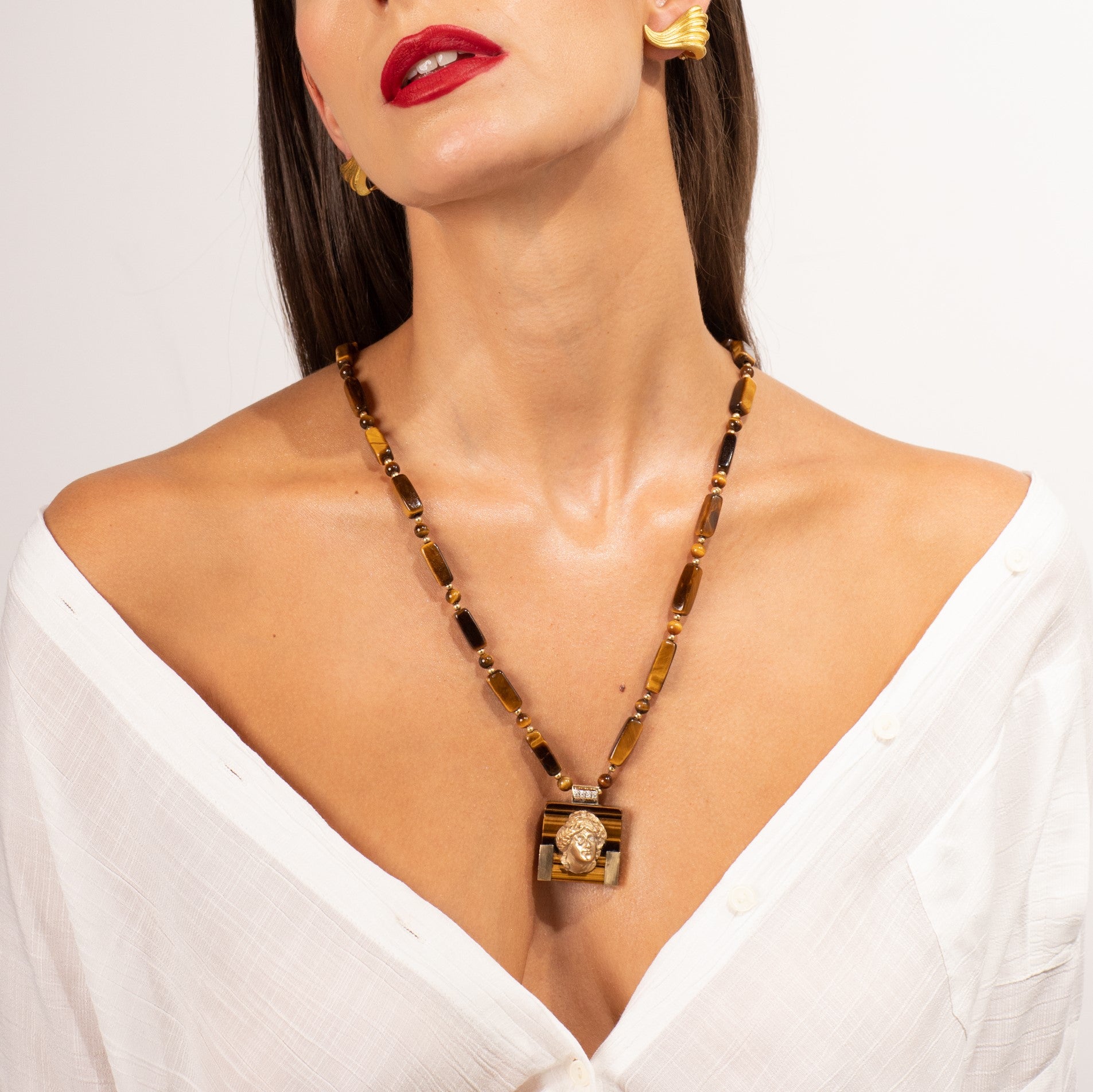 Tiger eye necklace with portrait pendant worn on a woman’s neck.