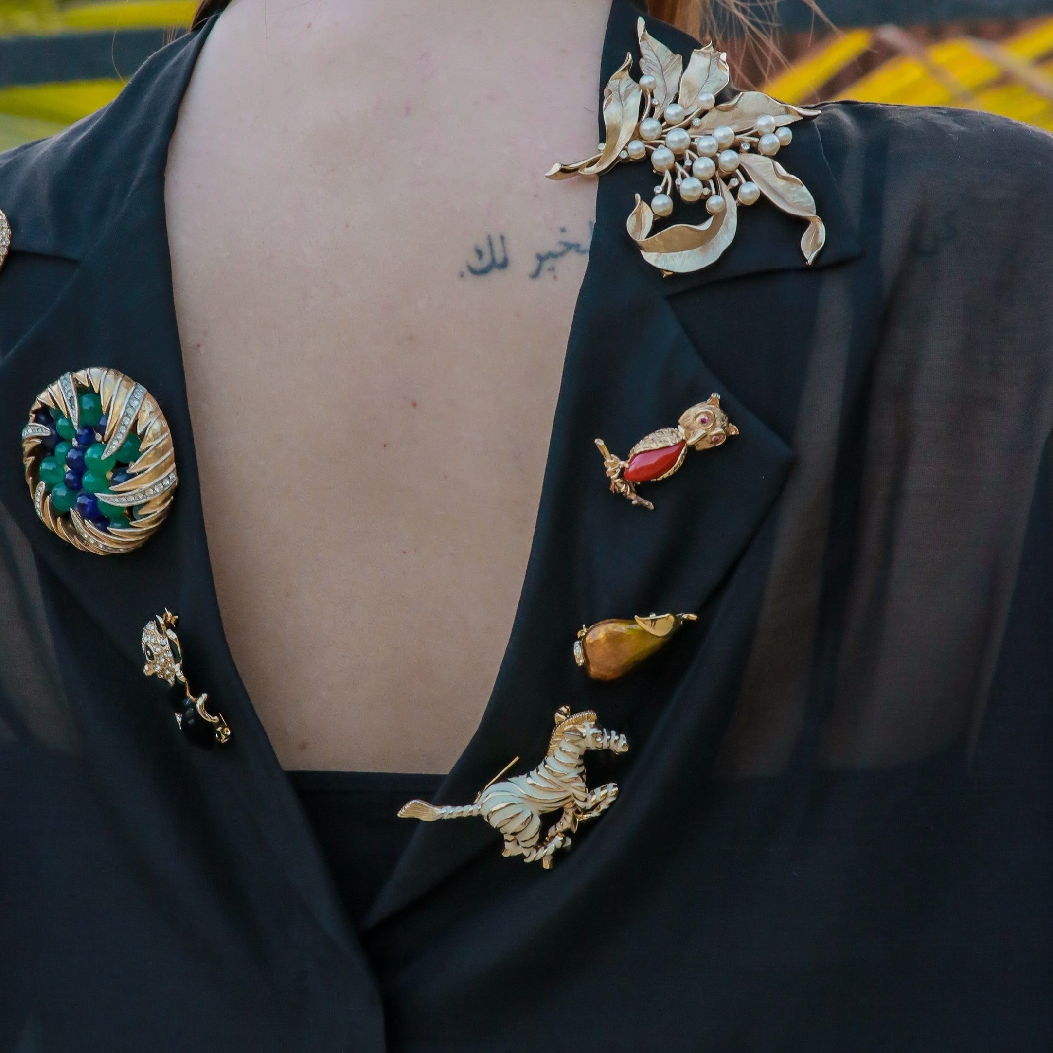 Collection of vintage brooches by YazJewels worn on woman’s shirt