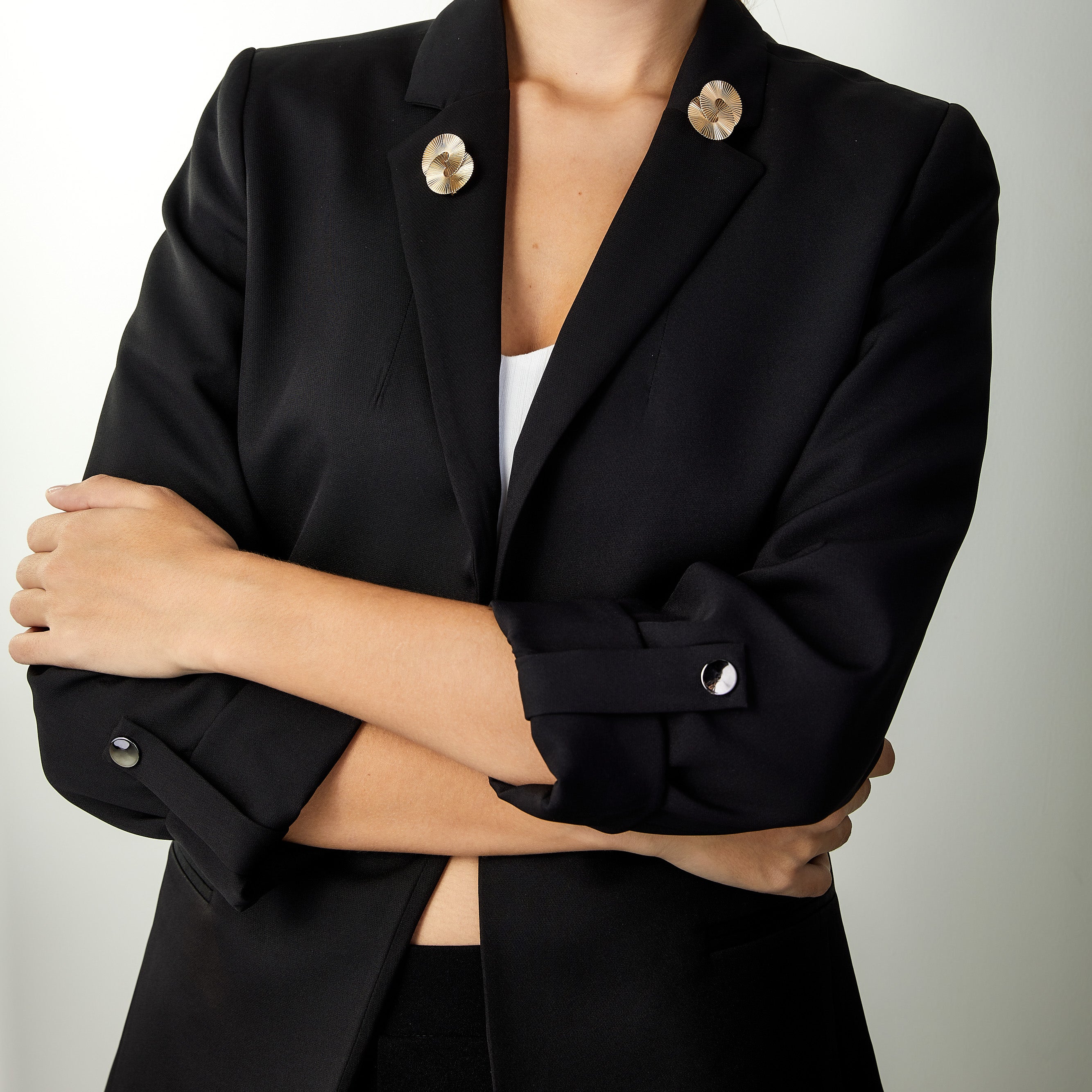 Retro geometric circle brooches worn separately on a woman’s lapel.