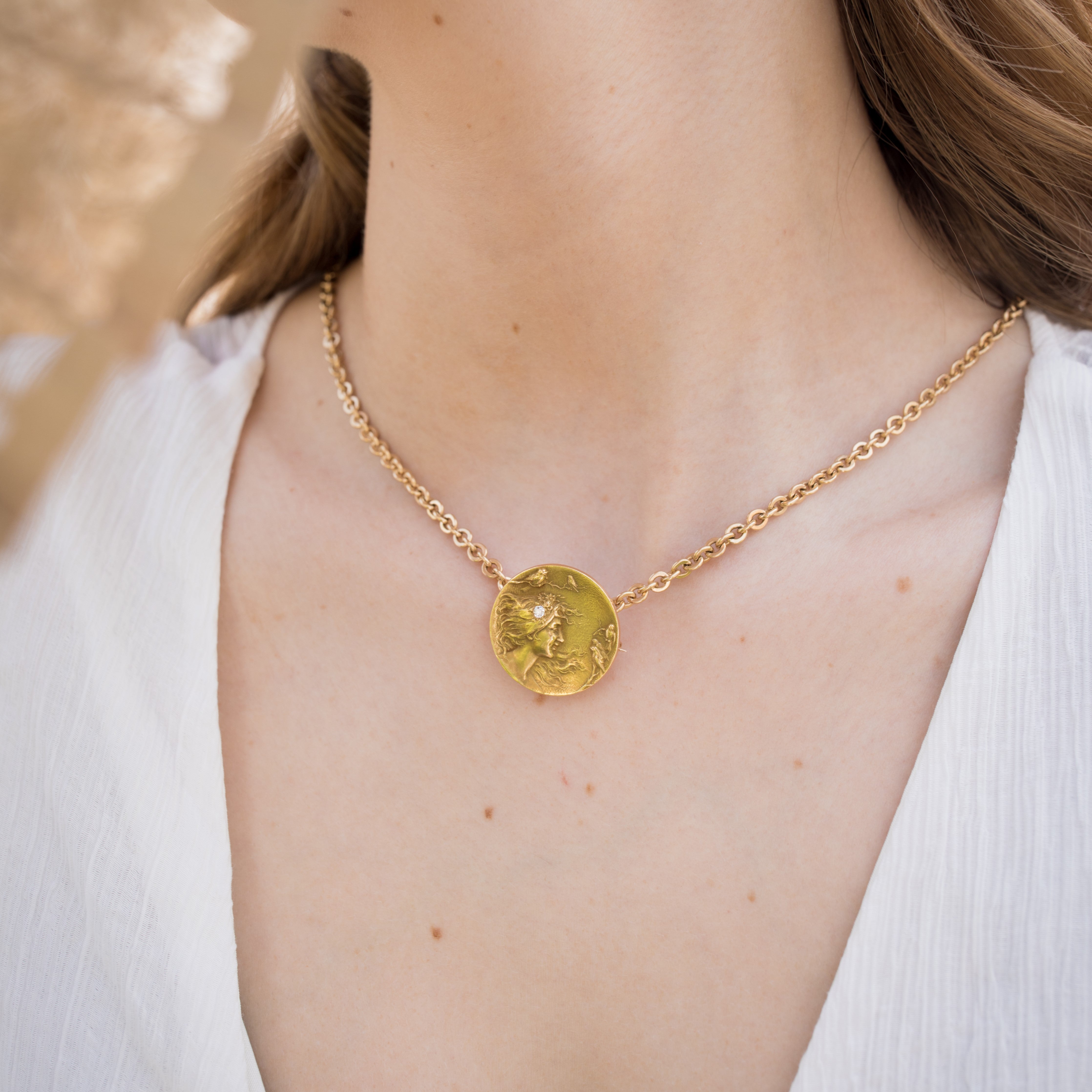 Art Nouveau pendant worn on a short chain around a woman’s neck.
