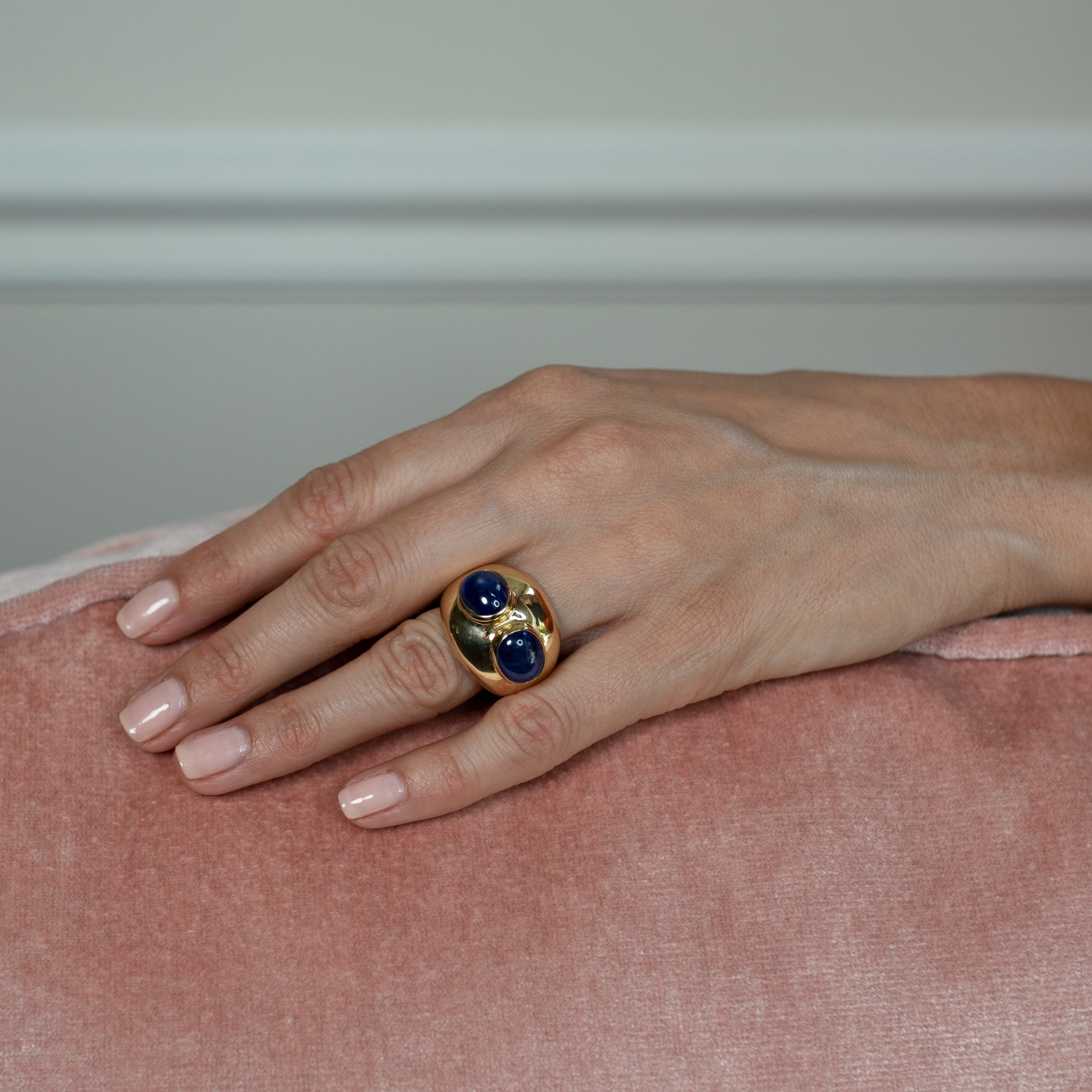 Blue sapphire ring in 18ct gold worn on women’s hand.