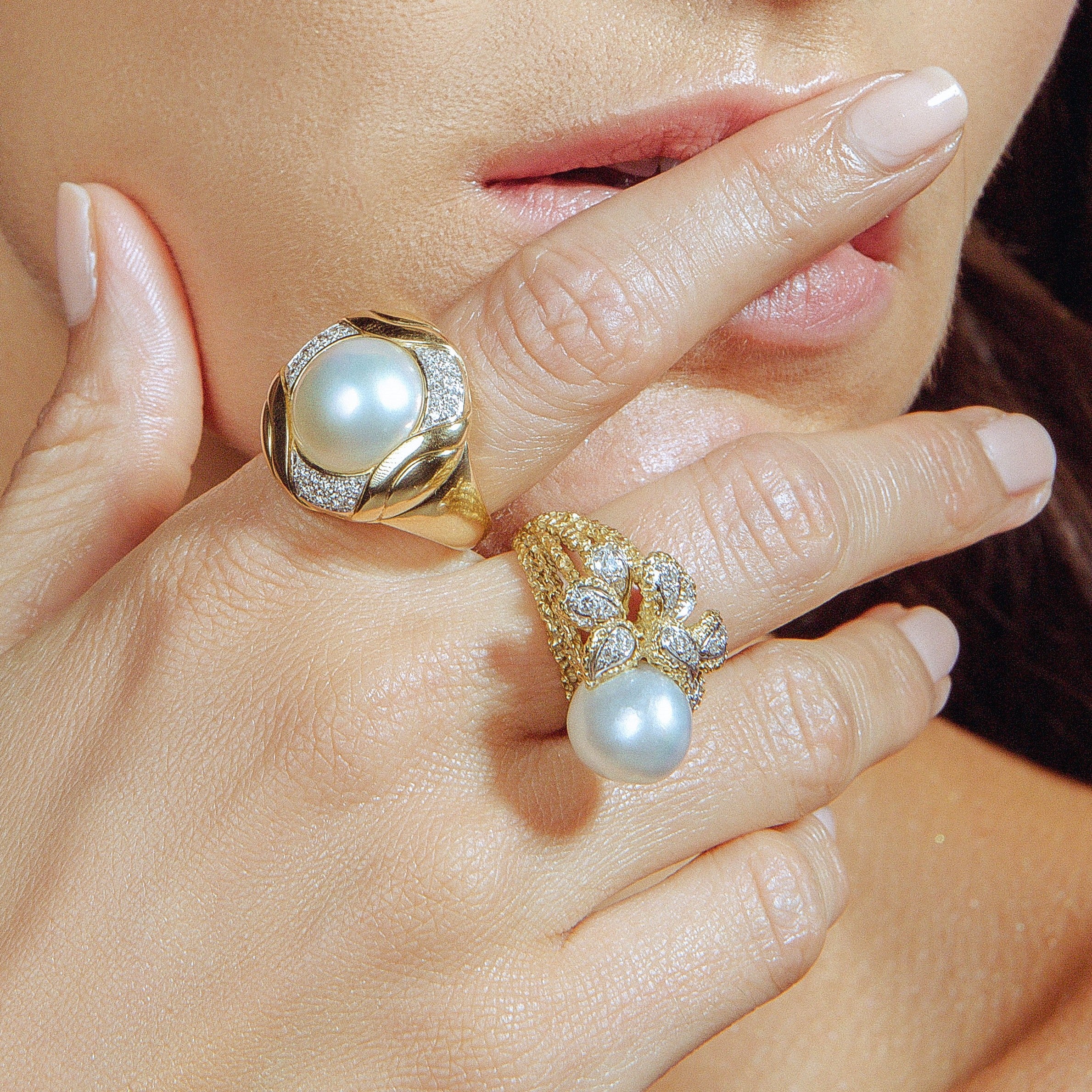 intage gold rings with pearls worn on a woman’s fingers.