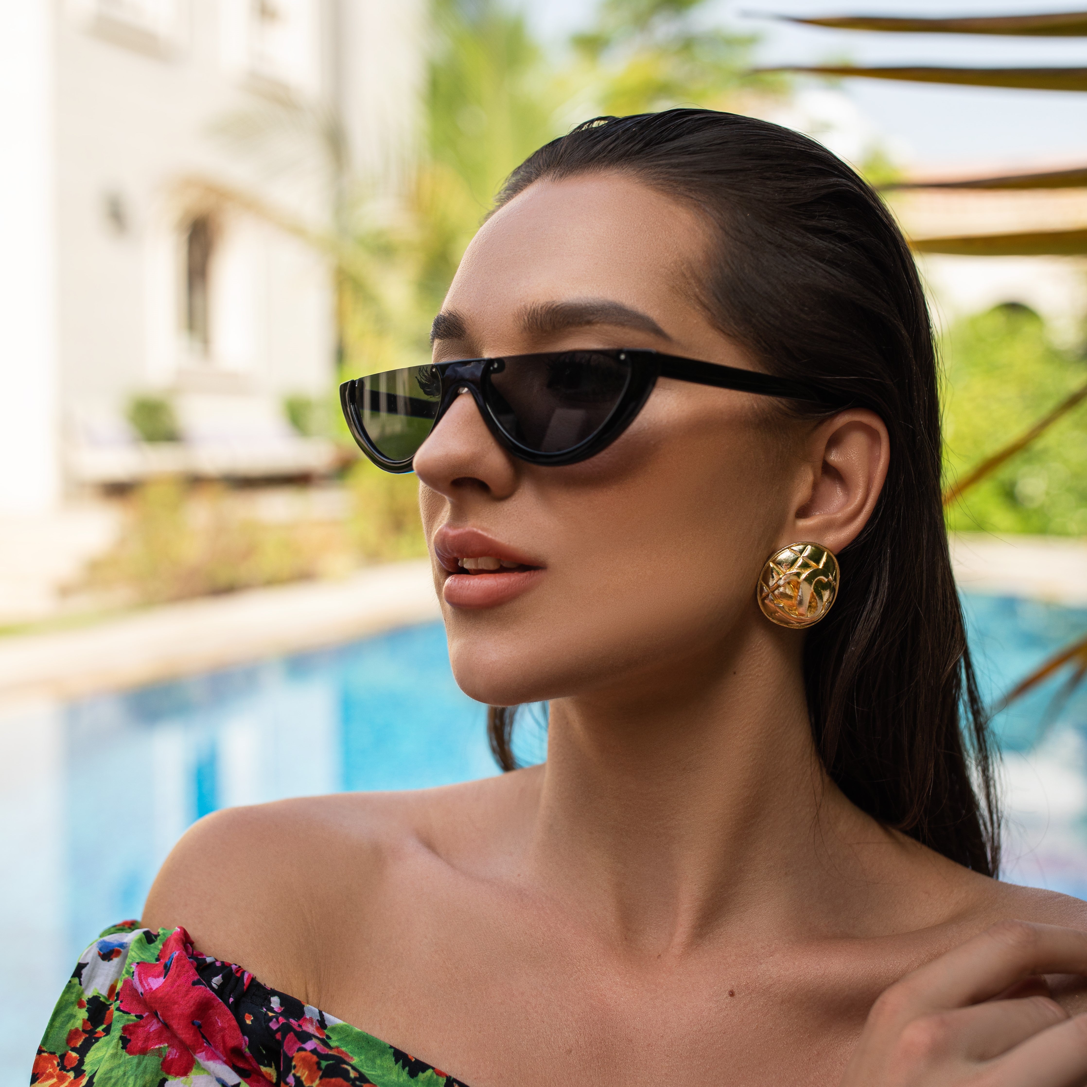 Woman standing by the pool wearing vintage Chanel earrings