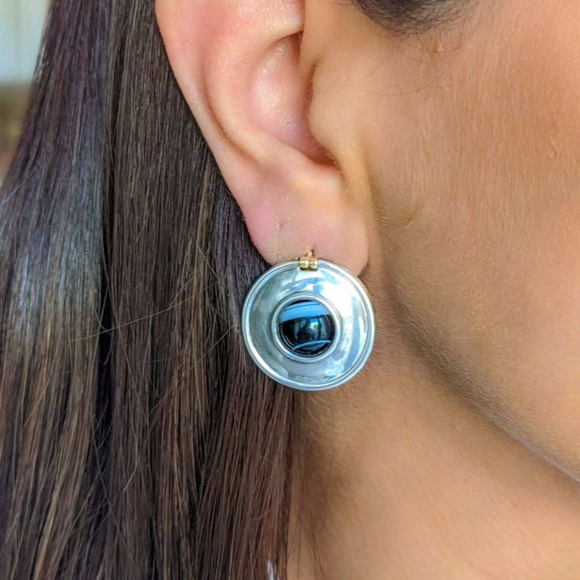 Vintage reversible earrings worn on the silver side on a woman’s ear.