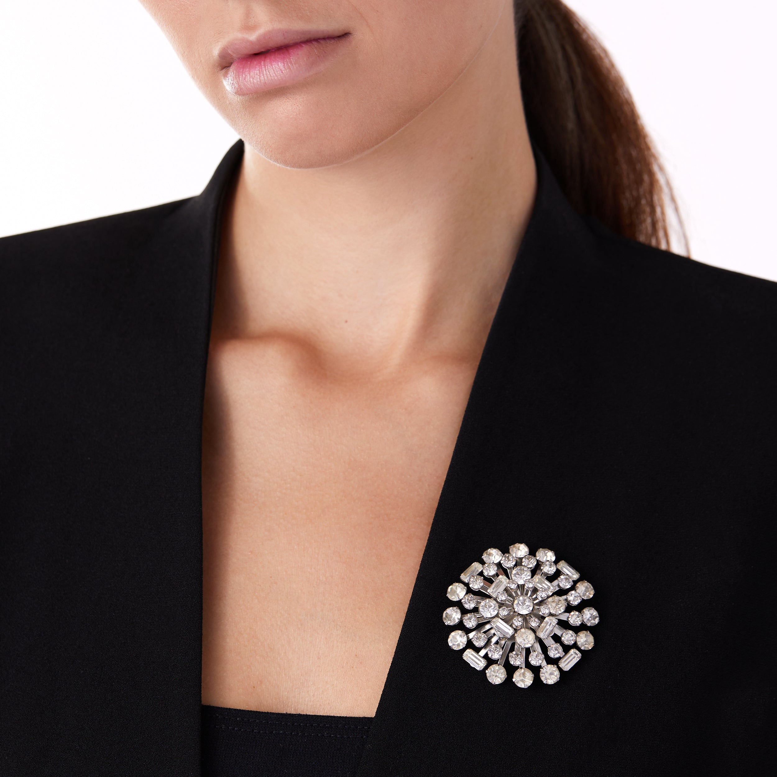 Vintage costume starburst brooch pin worn on woman’s lapel