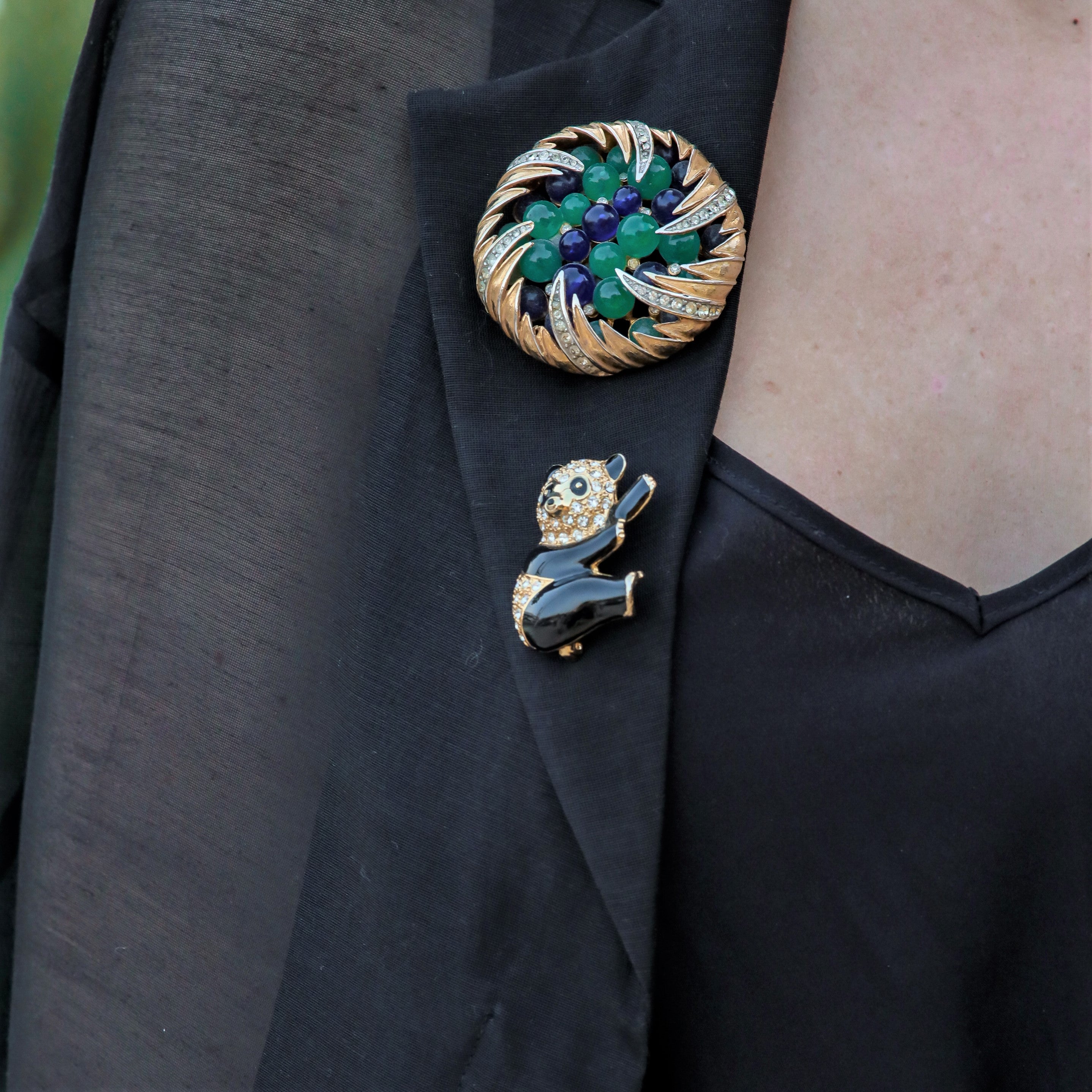 Contemporary panda pin brooch worn with a round brooch on a blazer lapel