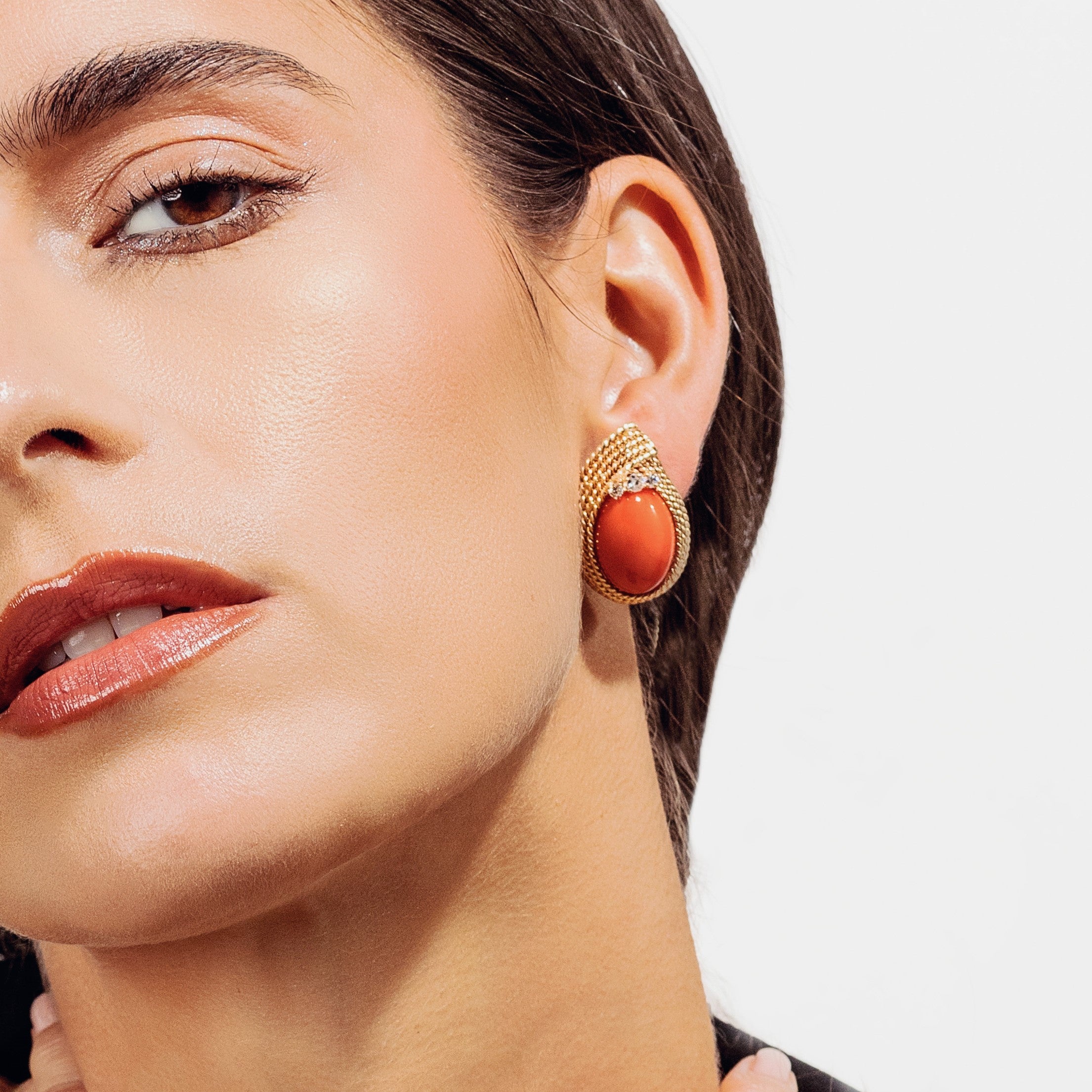 Woman wearing vintage pre-owned designer earrings with gold and corals