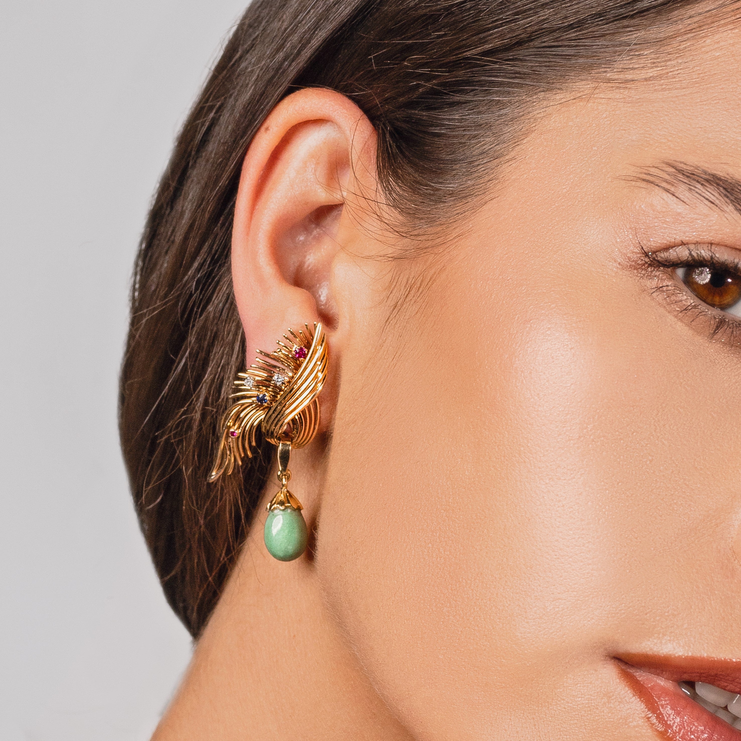 Vintage turquoise dangle earrings worn on a woman’s ear.