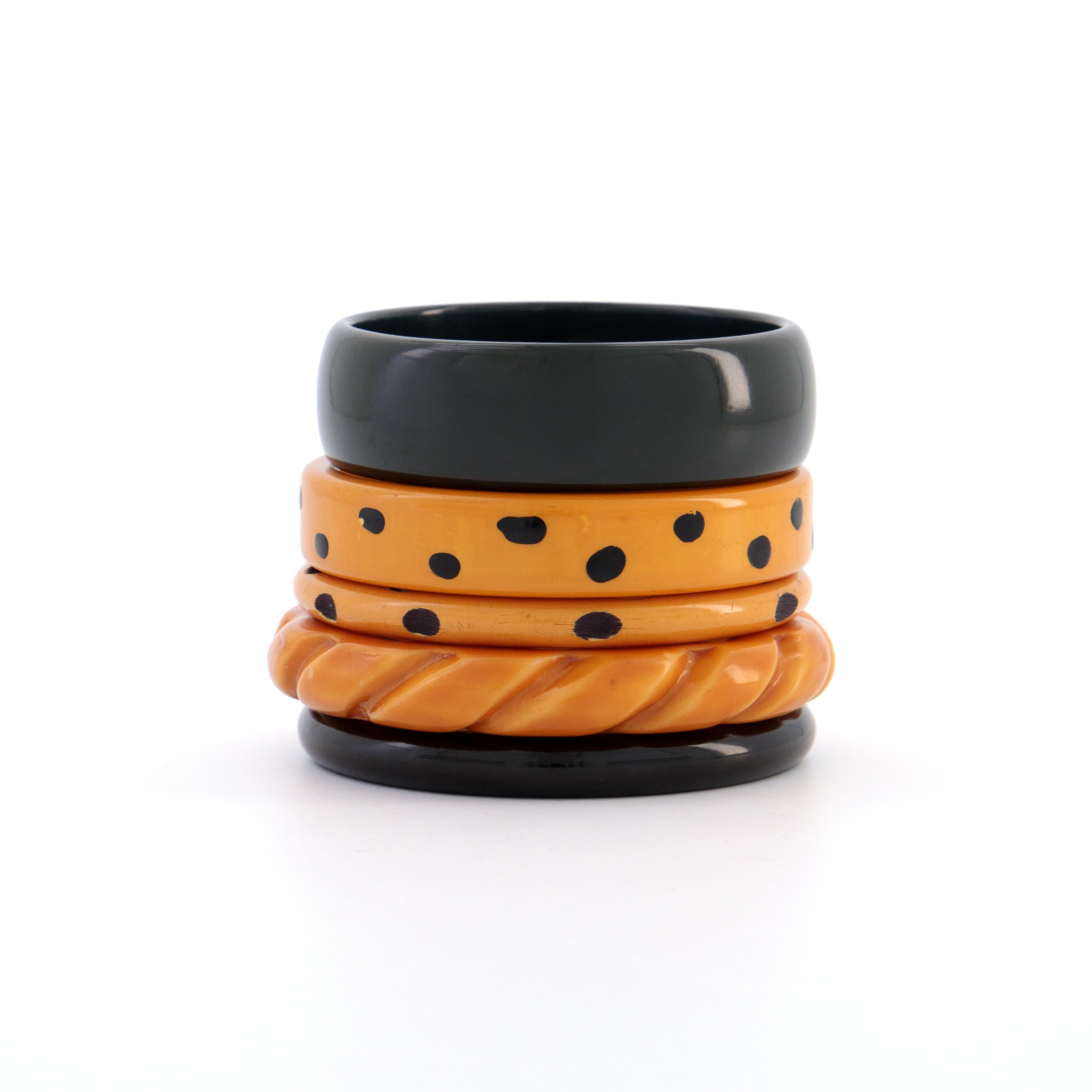 Five stacked Bakelite butterscotch, forest and black bangles