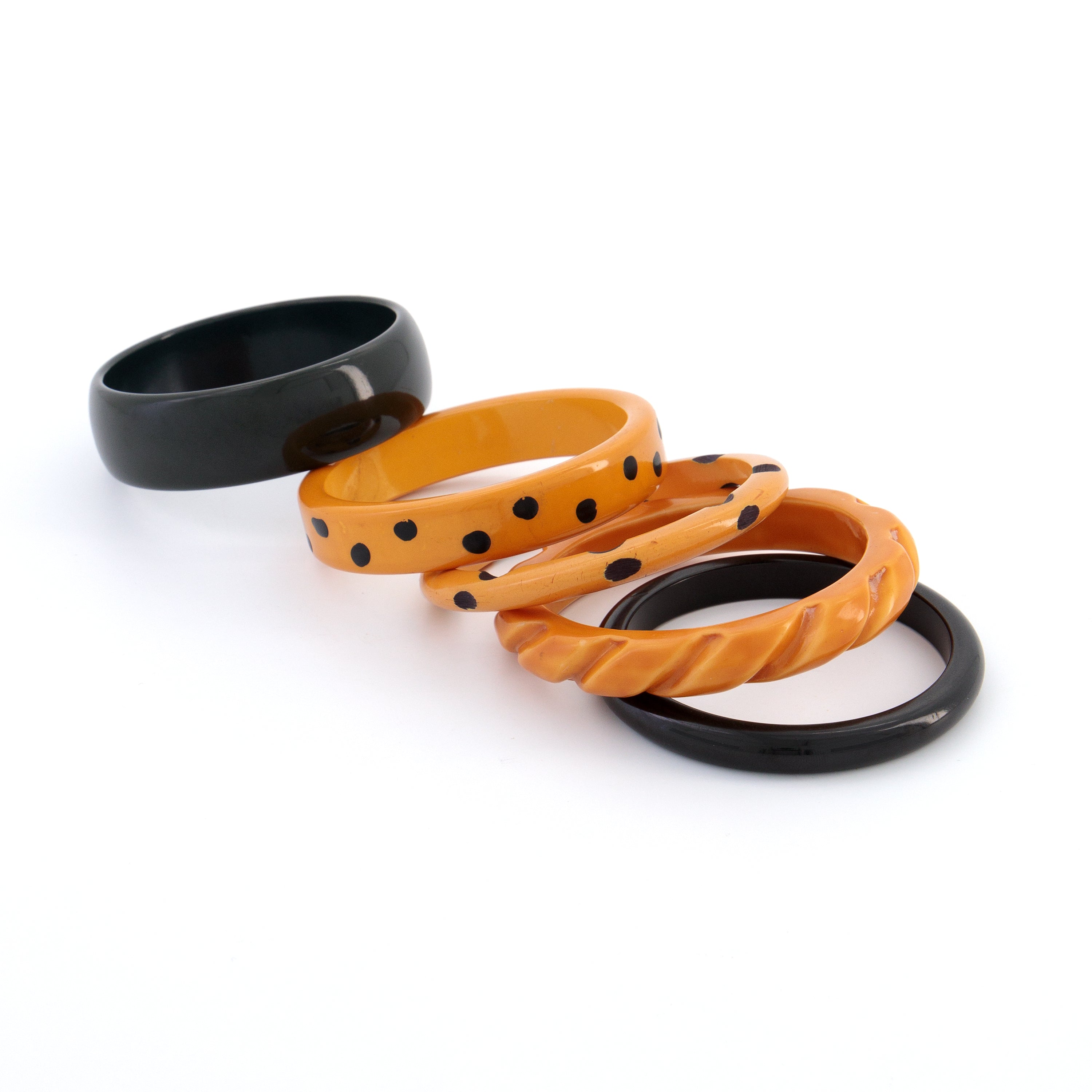 Five Bakelite bangles laid out on a white surface
