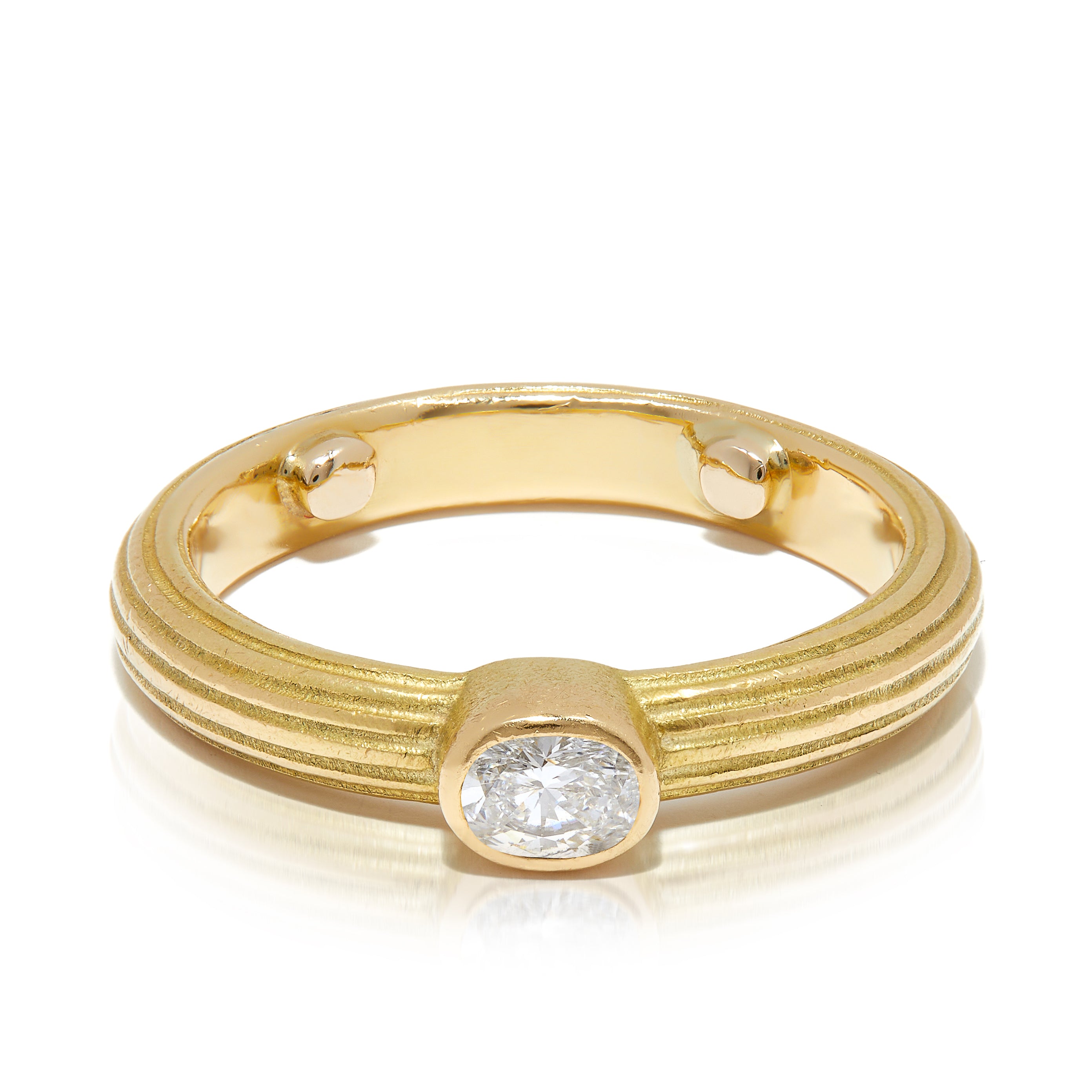 Fluted gold band ring with oval-cut diamond centre. 