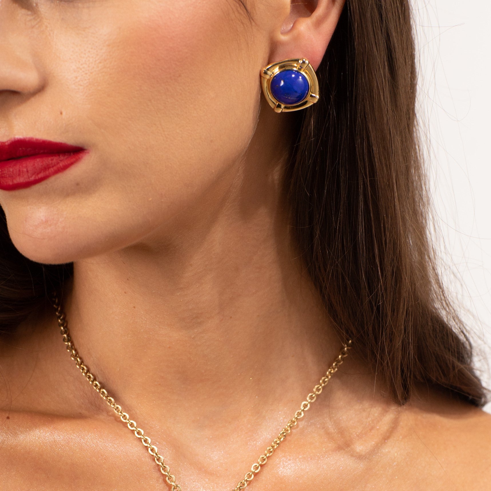 Woman wearing gold lapis lazuli earrings and gold chain necklace