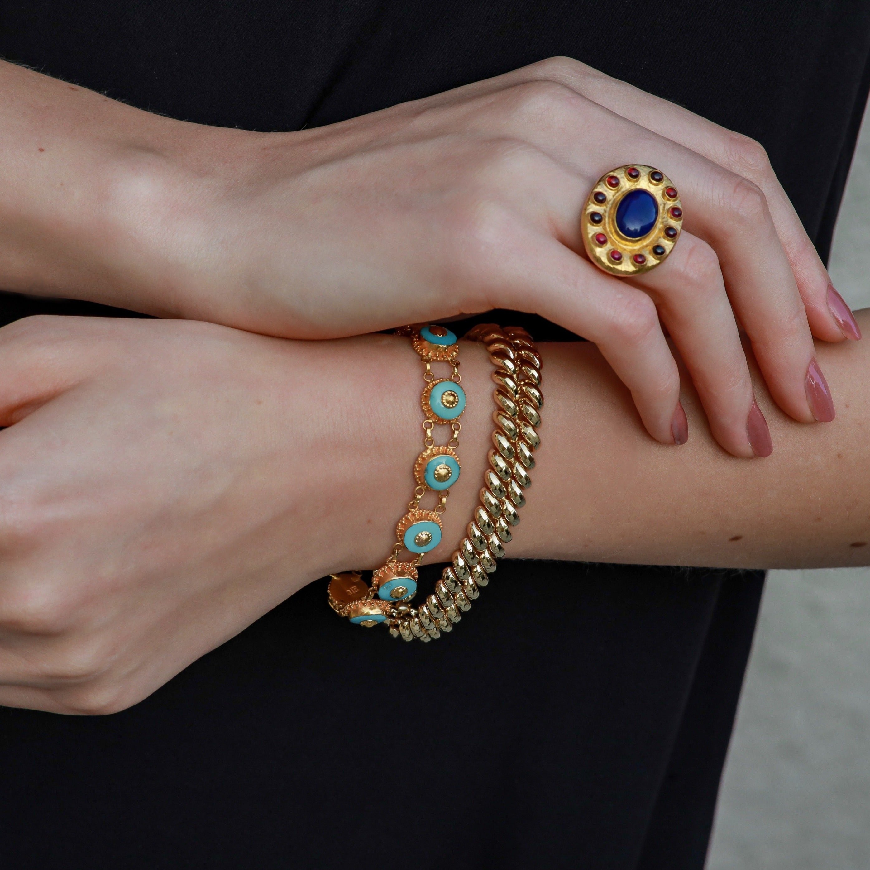 Vintage ring and bracelets worn on a woman’s hands.