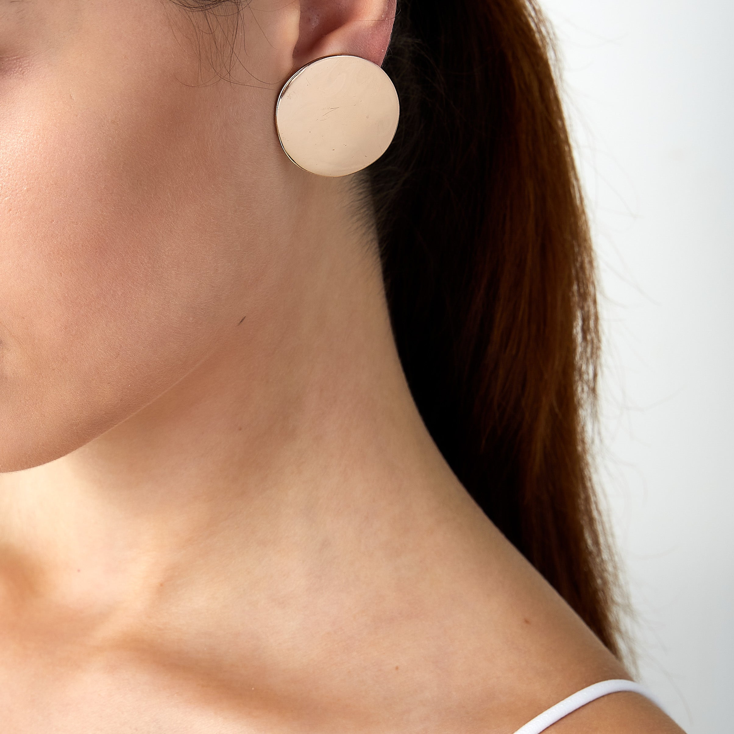 Vintage Robert Lee Morris disc clip earrings worn on a woman’s ear