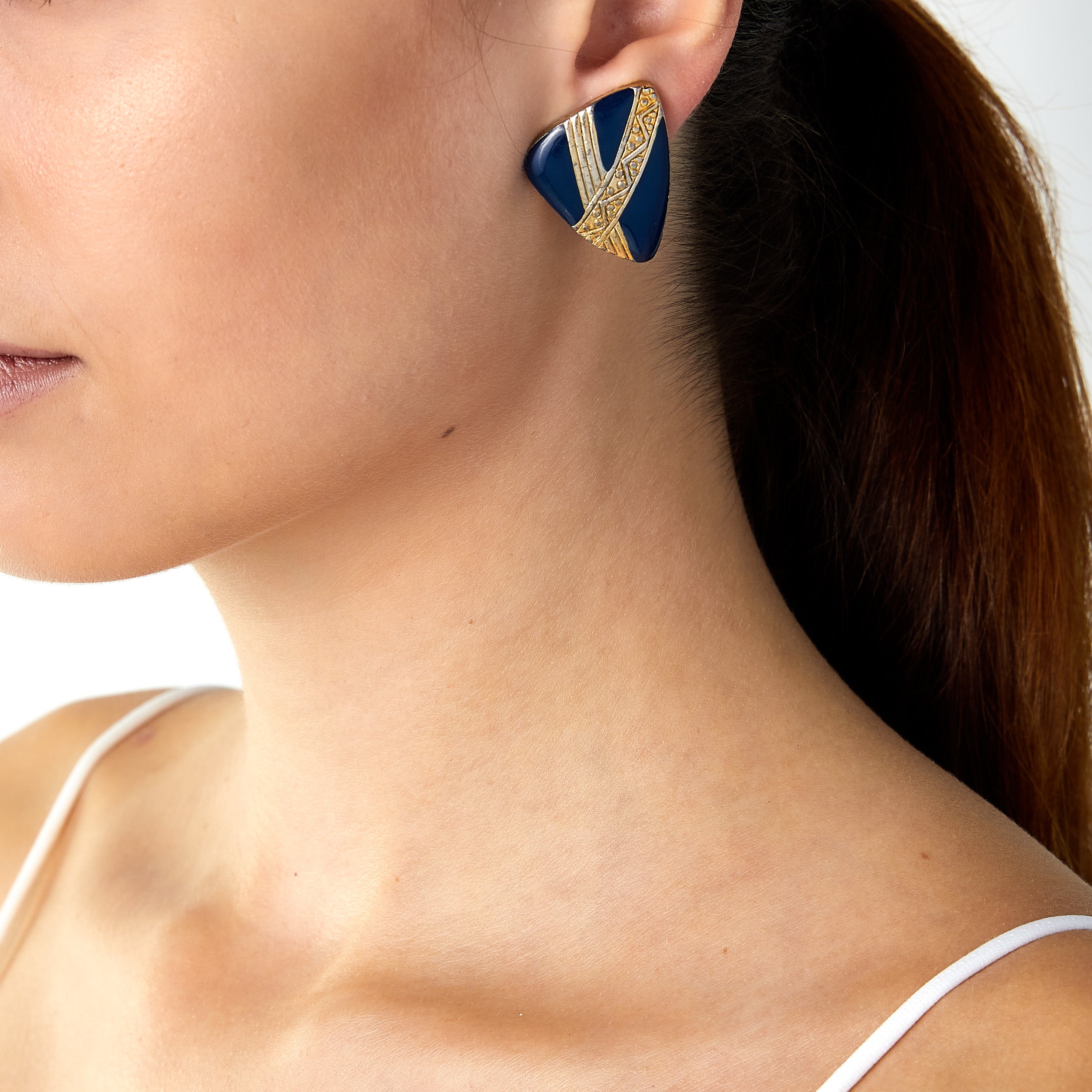 Vintage blue enamel geometric clip-on earrings worn on a woman’s ear